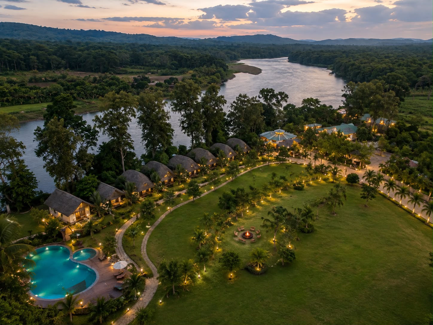 Aerial view of the entire Fortune Woods Dandeli property beside the river, with cottages, lawn and pool